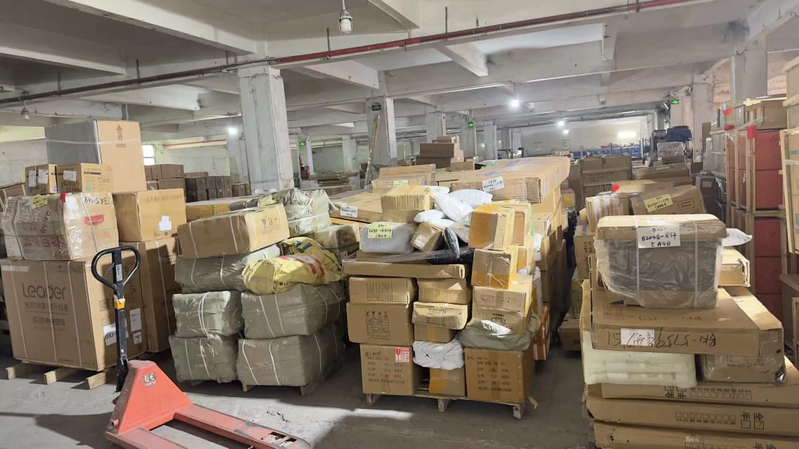 Warehouse pallets of cartons and woven cargo sacks staged for consolidated freight shipping from China to Malaysia